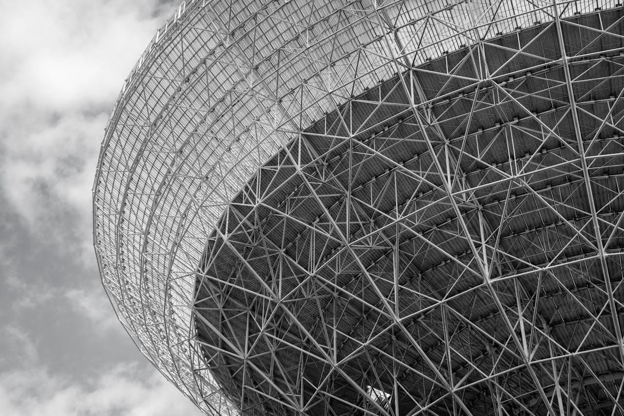 Geometric black and white photo of a futuristic steel structure, showcasing modern architectural design and patterns.